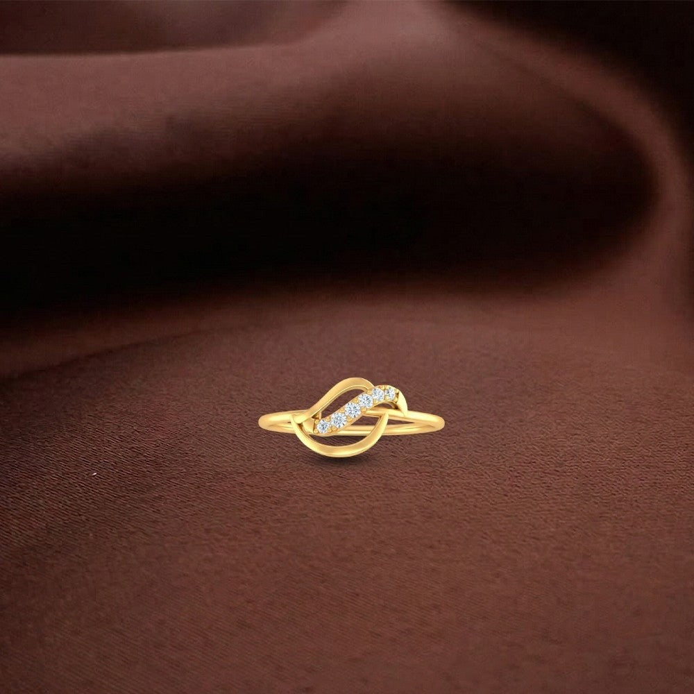 Gold and diamond women's ring on a brown surface.
