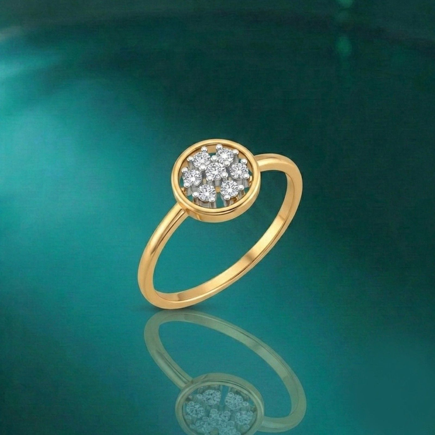 A gold ring with a round cluster, displayed on a reflective dark teal surface.