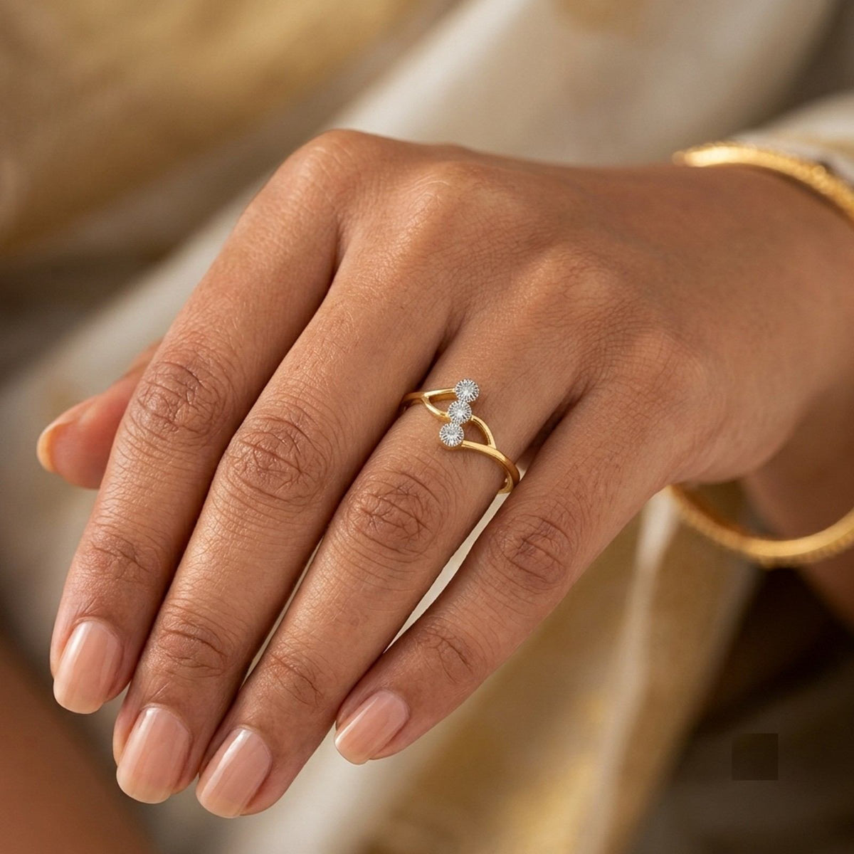 Gold and diamond ring on a person's finger.