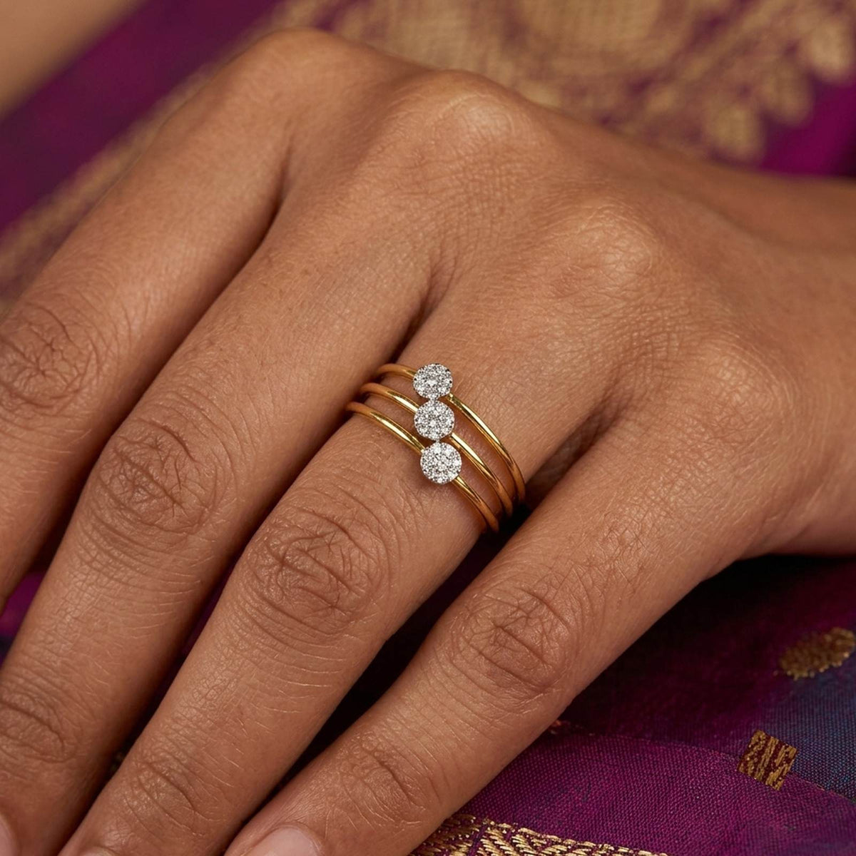 Gold ring with three diamond stones on a hand