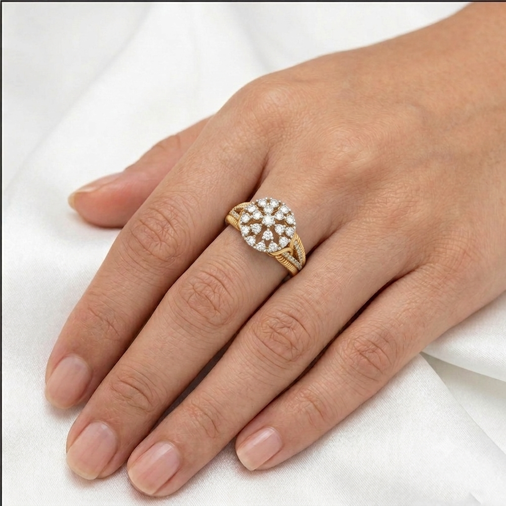 A close-up of a hand wearing a gold ring with a diamond pavé cluster, resting on a soft white fabric background.