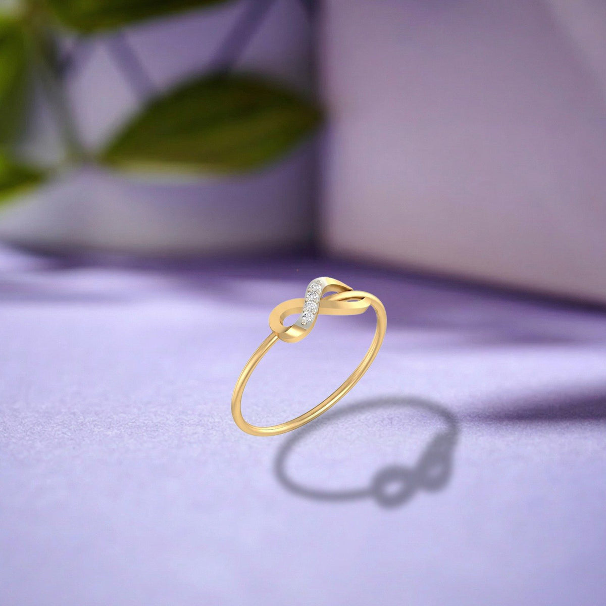 Gold and diamond with infinity design on a purple surface.