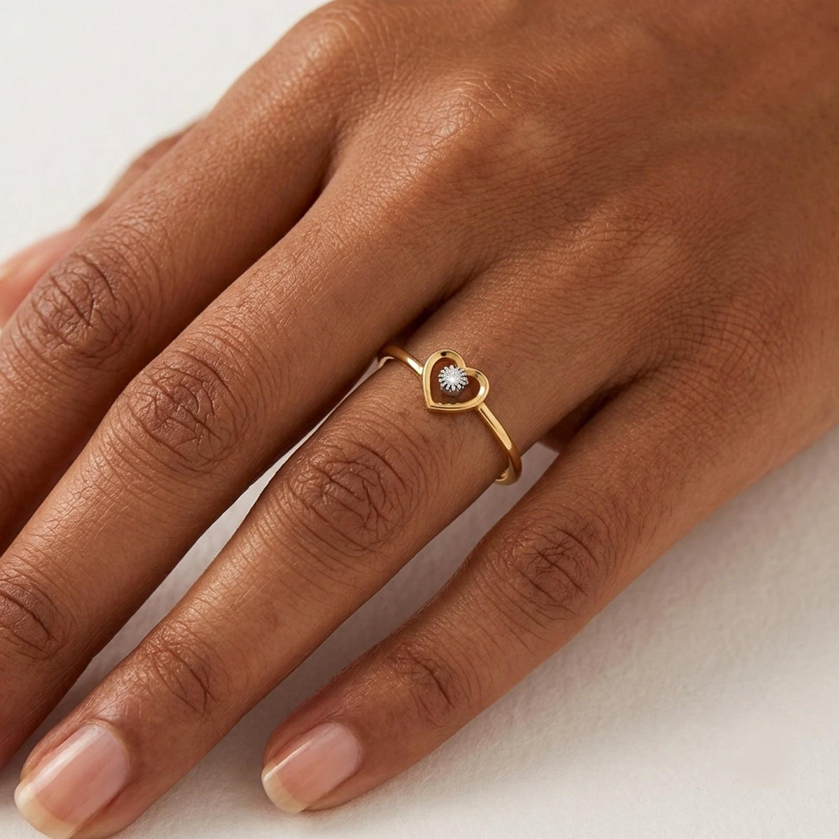 Gold and diamond with heart-shaped on a person's finger.