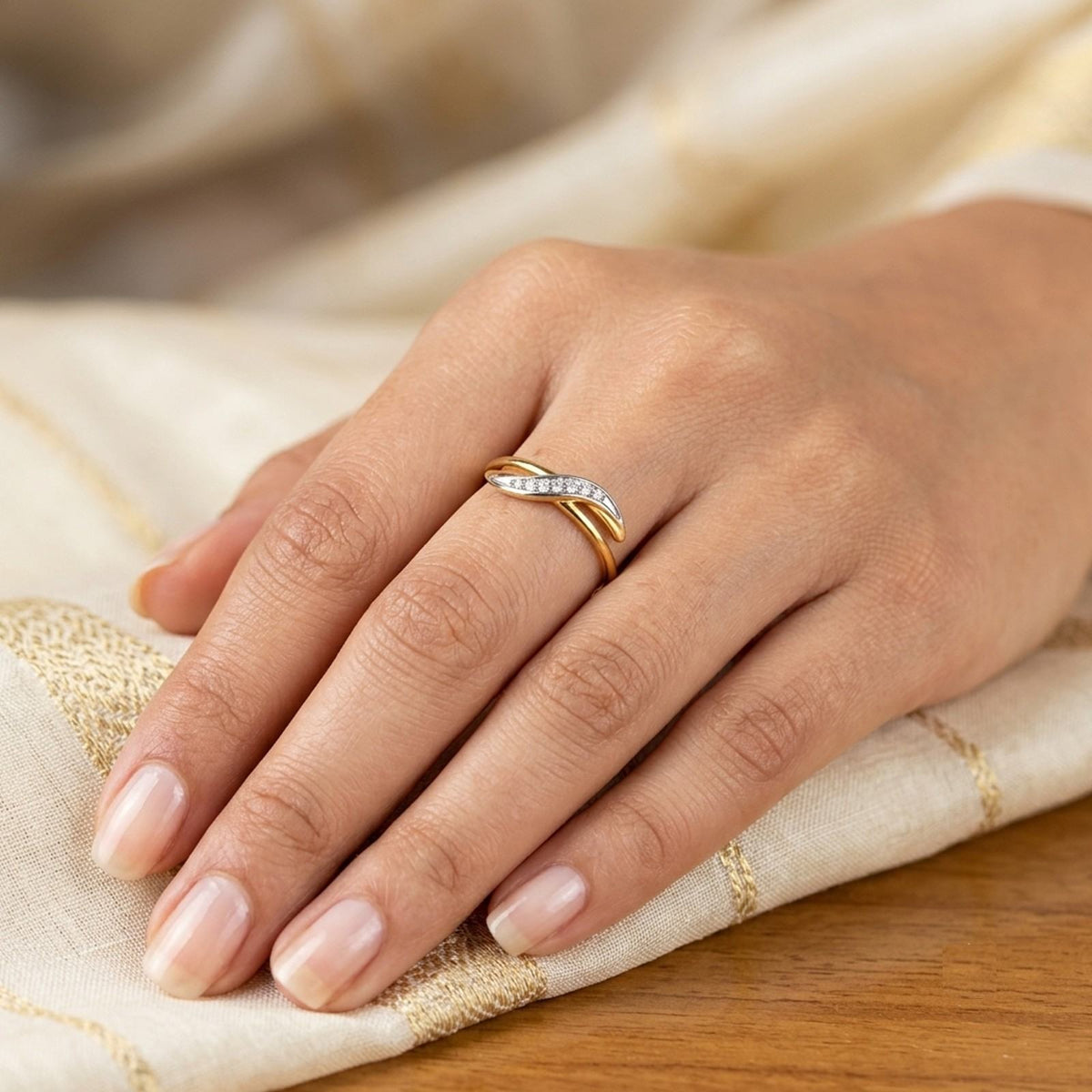 Gold and diamond women's ring on a person's finger.
