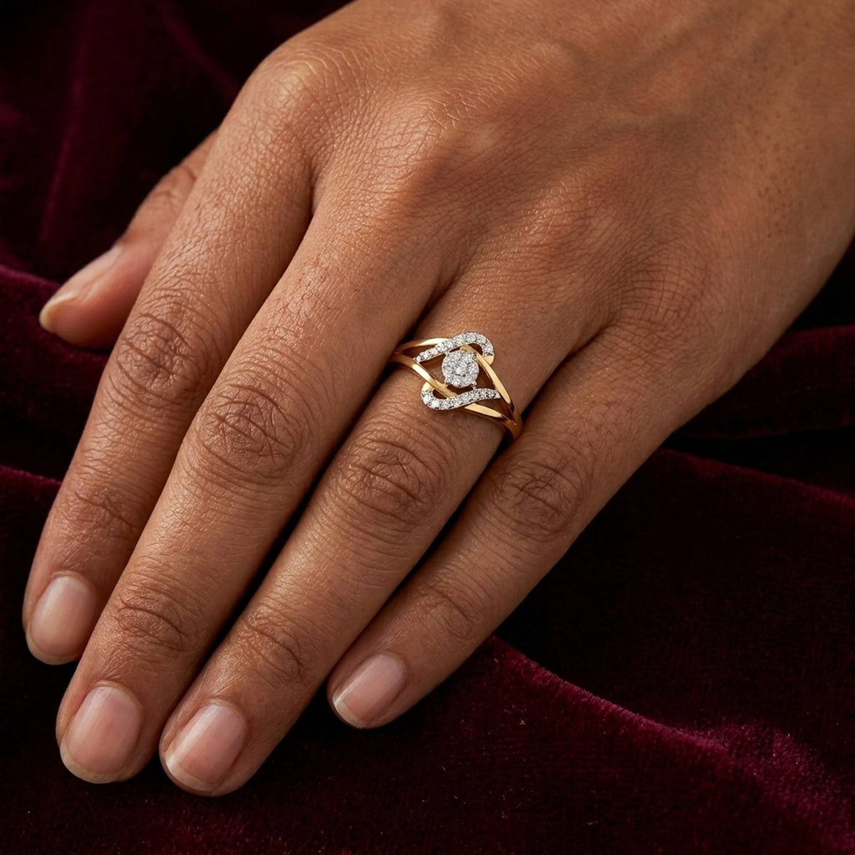 Gold ring with a central round diamond, shown on a person's finger.