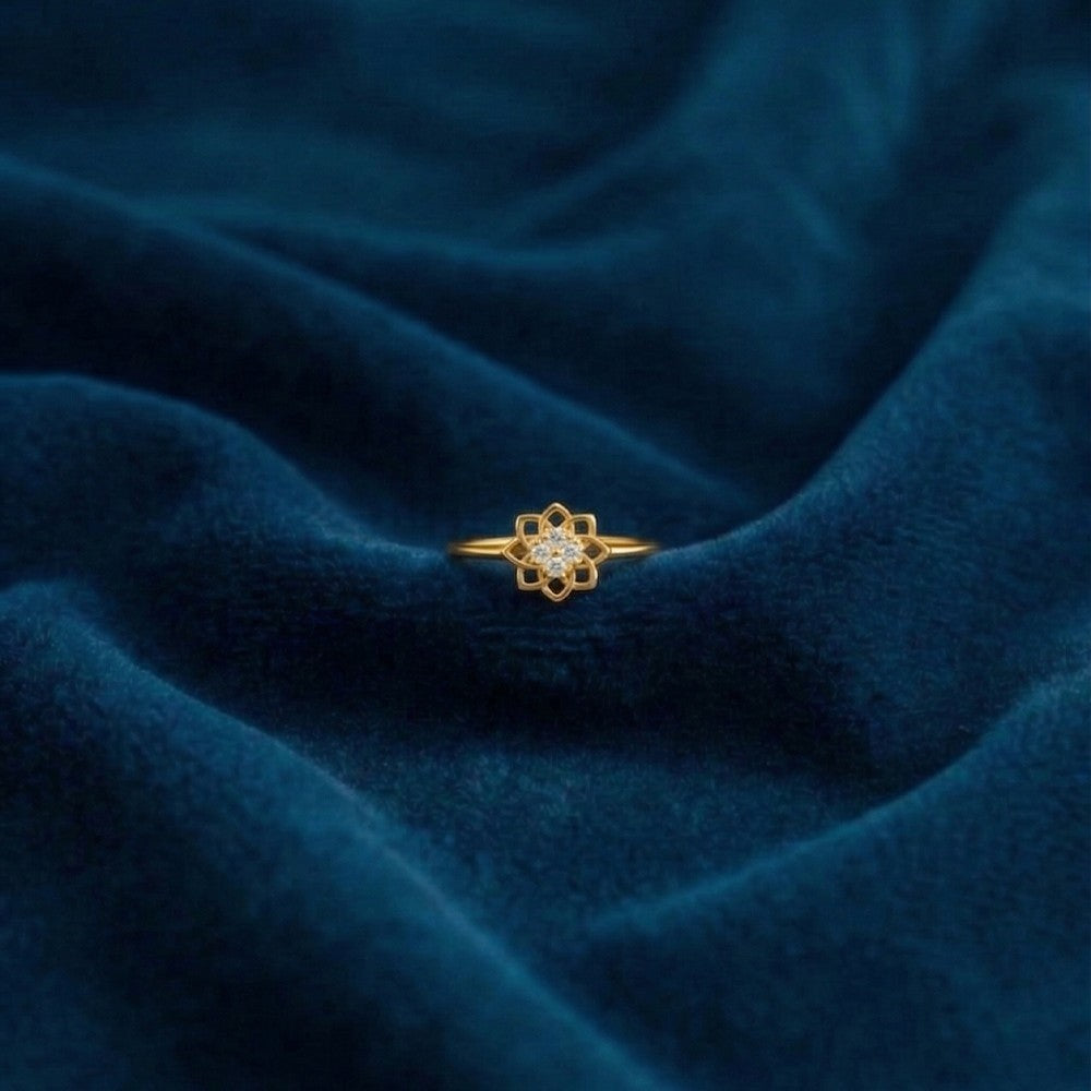 Gold ring with a diamond on a blue textured fabric background