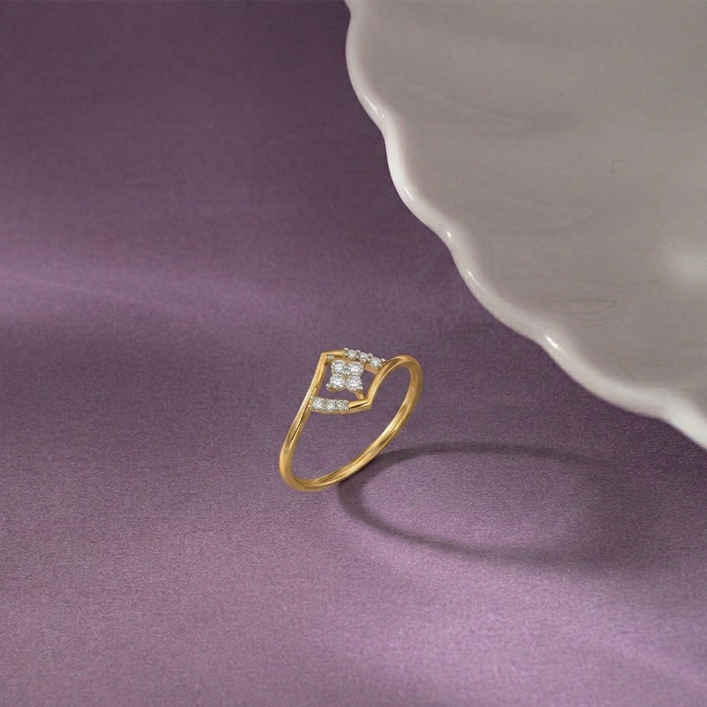 Gold and diamond with floral-design cluster setting on a purple surface.