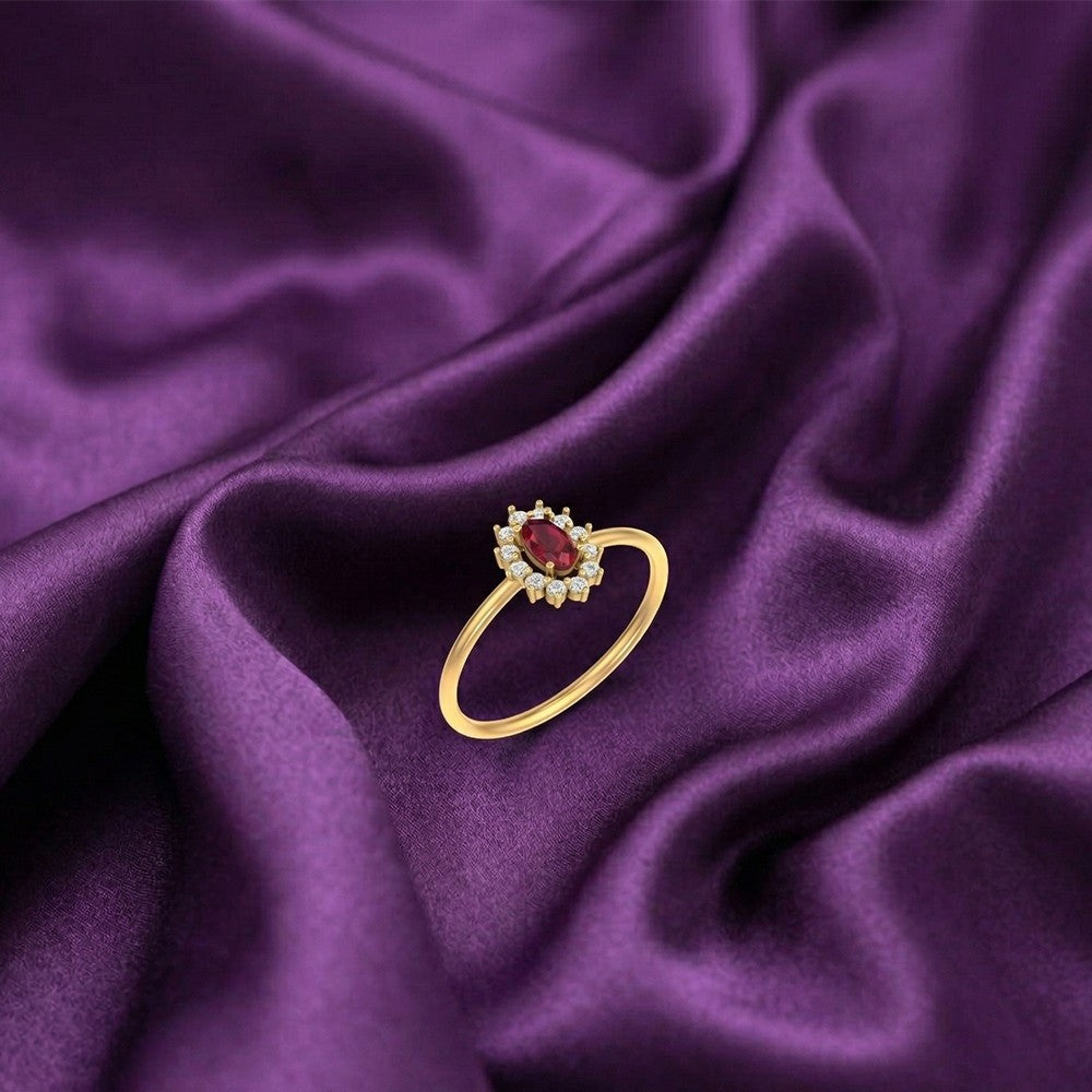 Gold and diamond with oval-shaped ruby gemstone setting on a satin fabric surface.