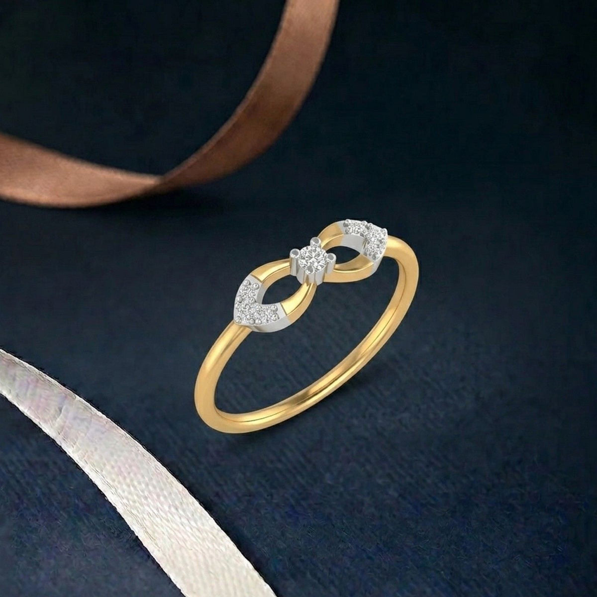 A gold ring with a double infinity symbol design, displayed on a dark textured background.