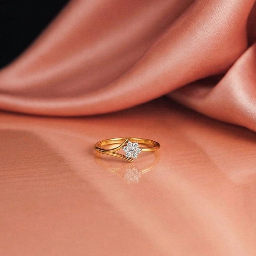 Gold ring with a floral-design diamond on a pink fabric background