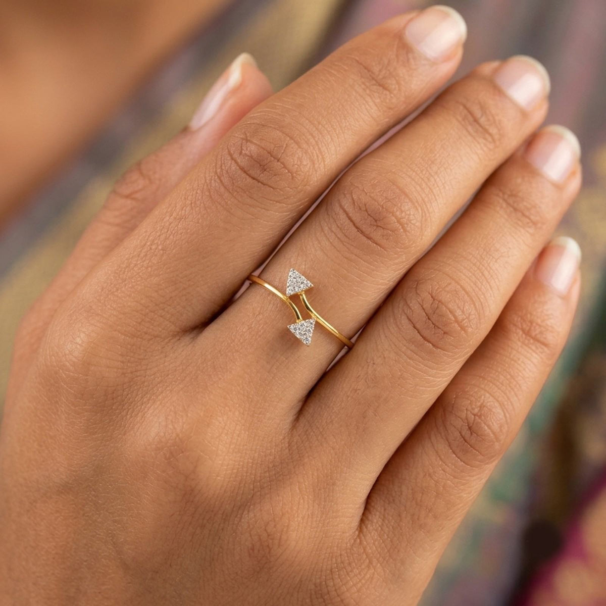 Close-up shot of a gold ring with two triangular cluster settings.