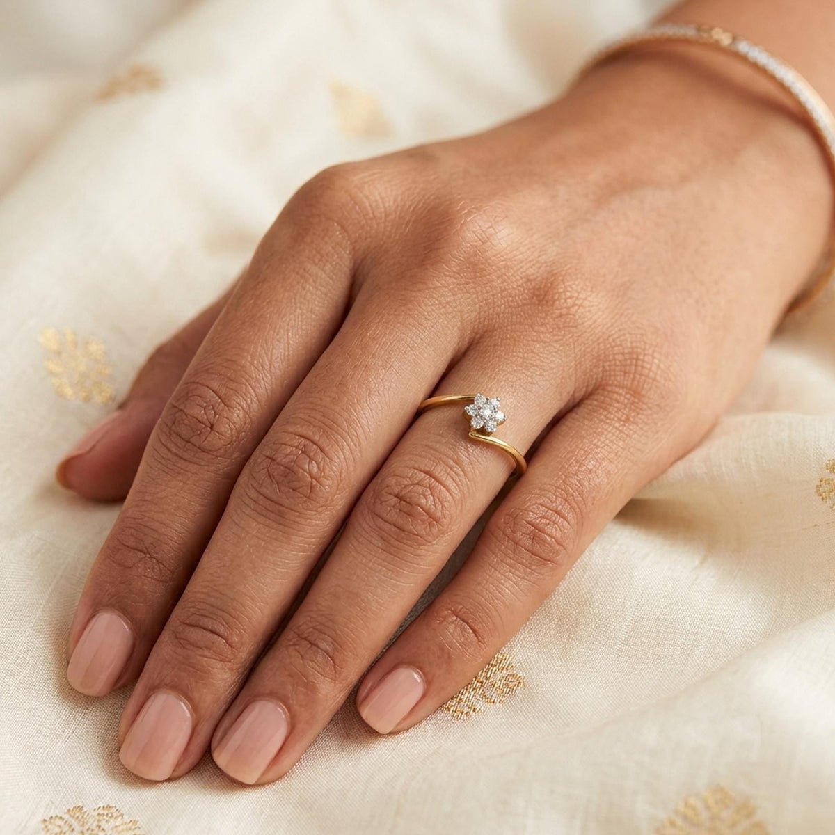 Gold and diamond with cluster setting on a person's finger.