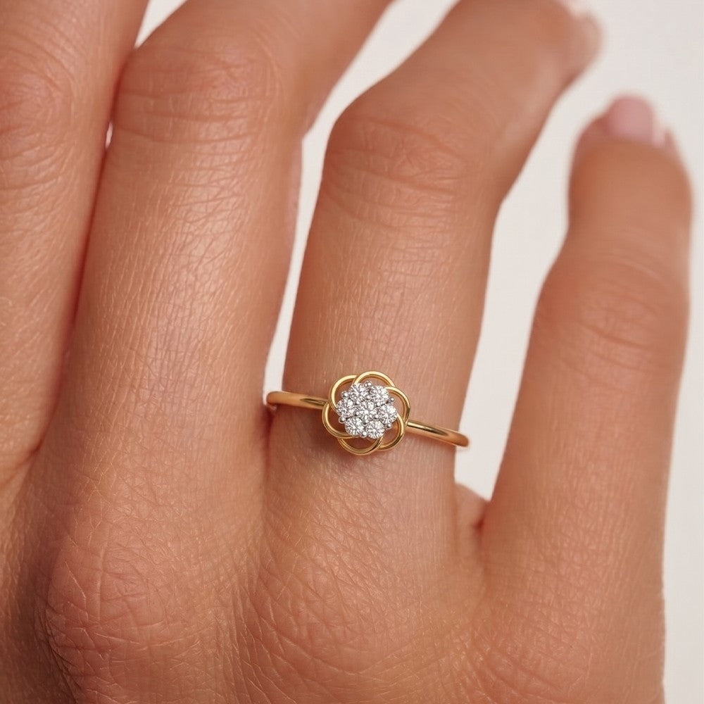 Gold ring with a diamond on a person's finger against a white background