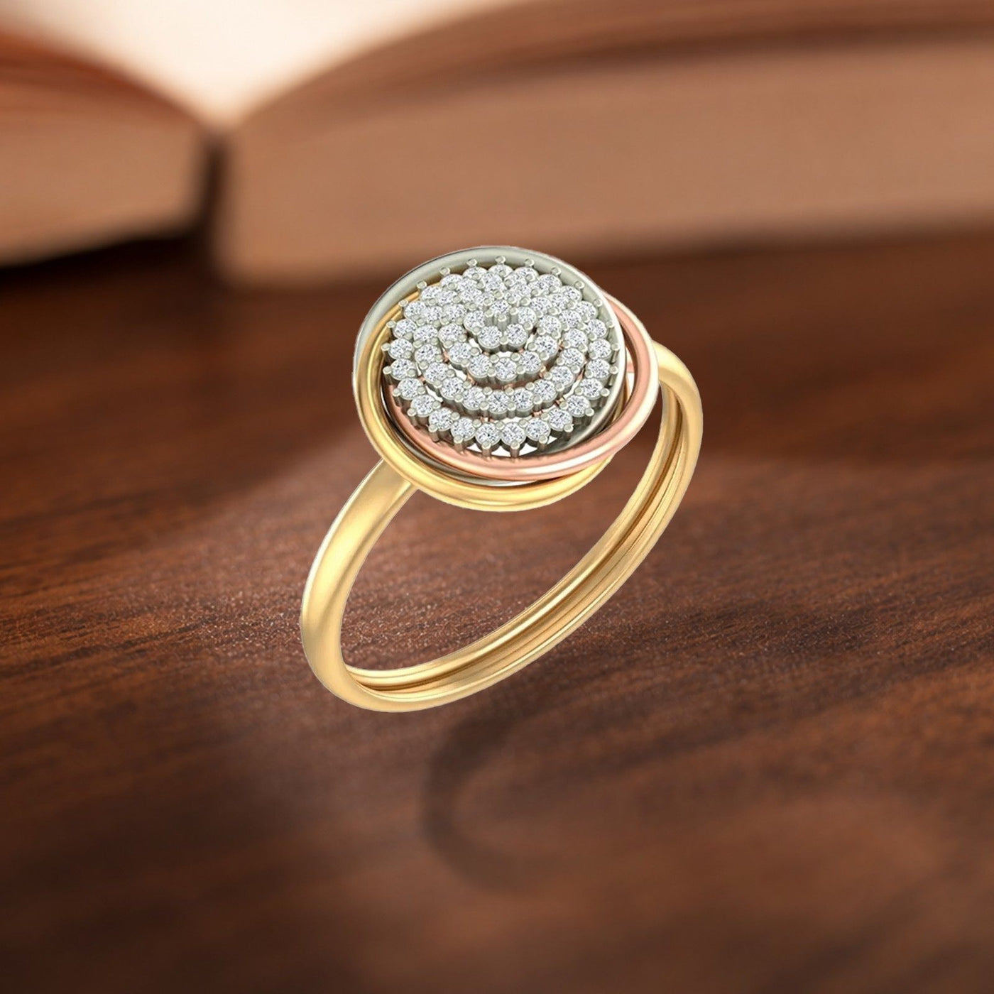 Gold and diamond ring with a cluster center setting on a wooden surface.