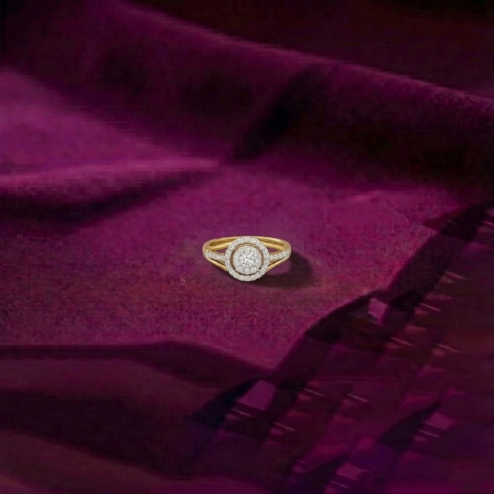 A gold ring with a, resting on draped purple fabric.