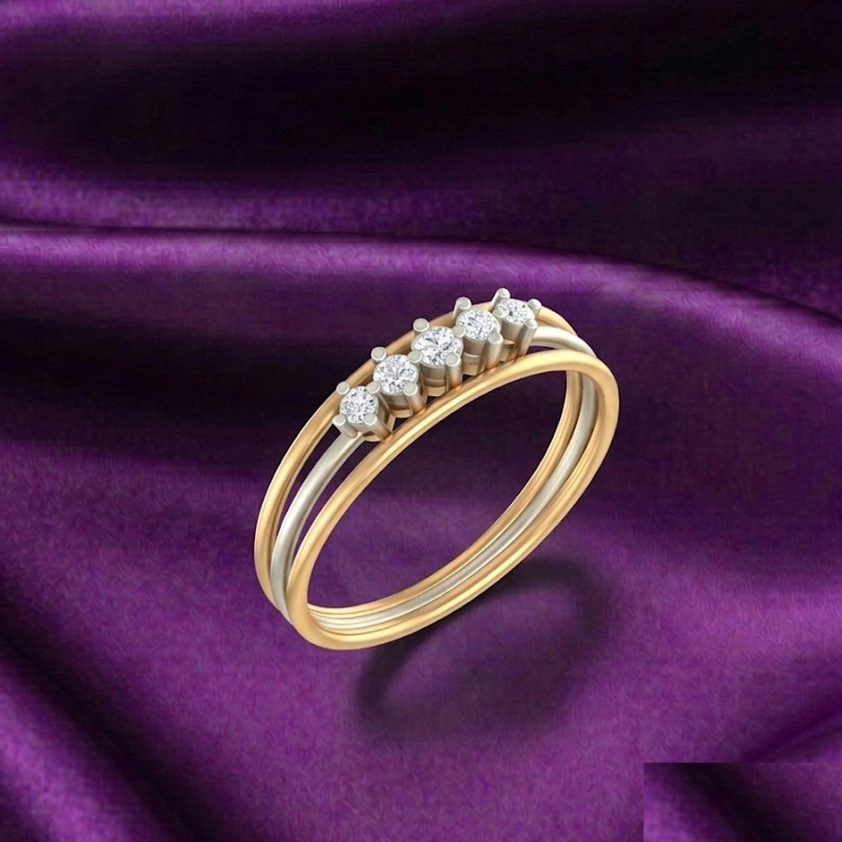 Gold and diamond band women's ring on a purple surface.