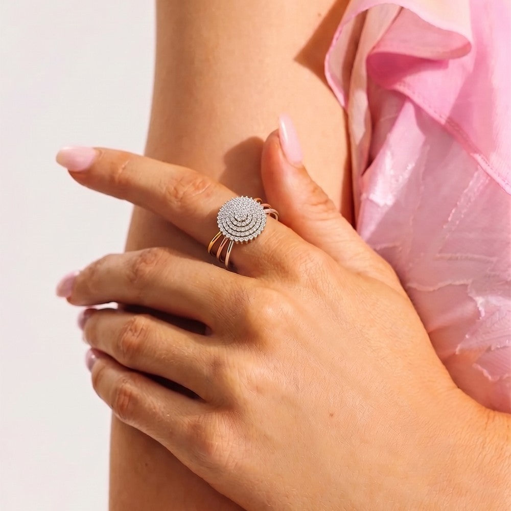 Close-up of a hand wearing a silver ring with a pink garment in the background