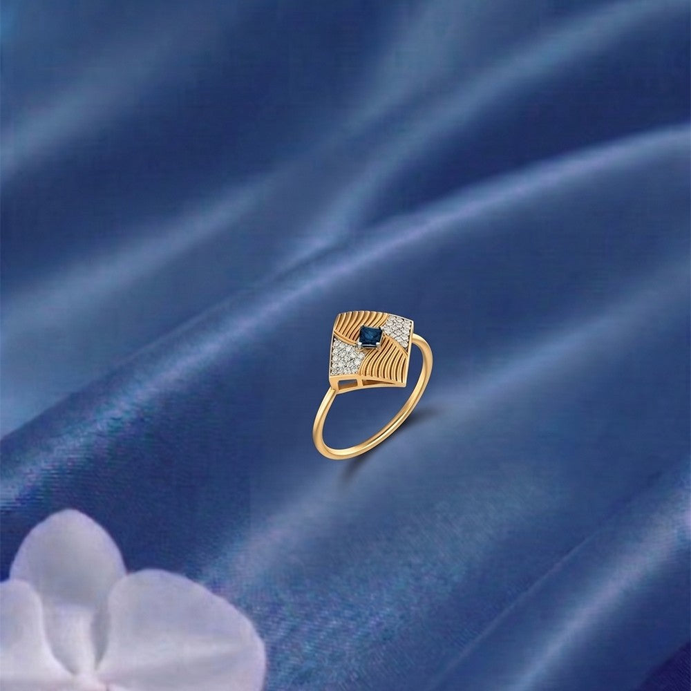 Gold and diamond with sapphire gemstone on a blue surface.