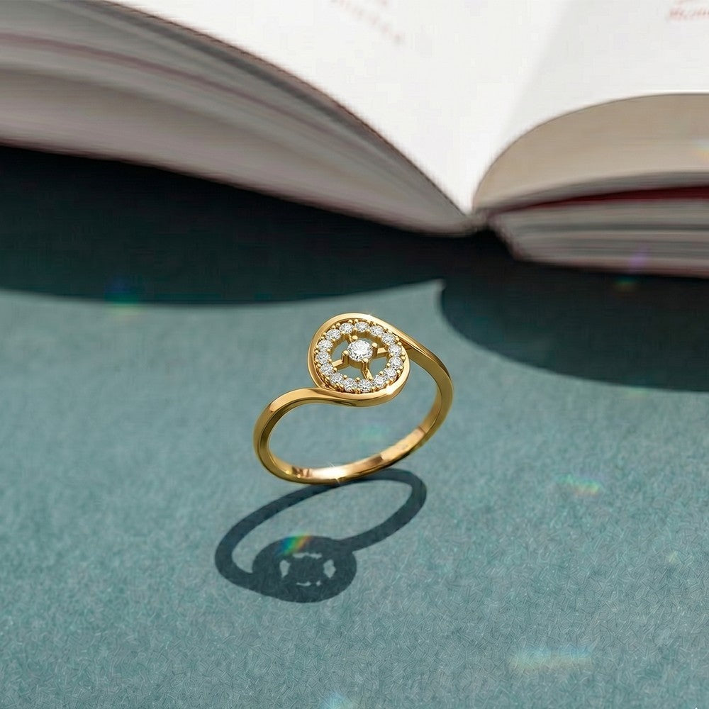Gold and diamond ring with halo setting on a blue surface. 