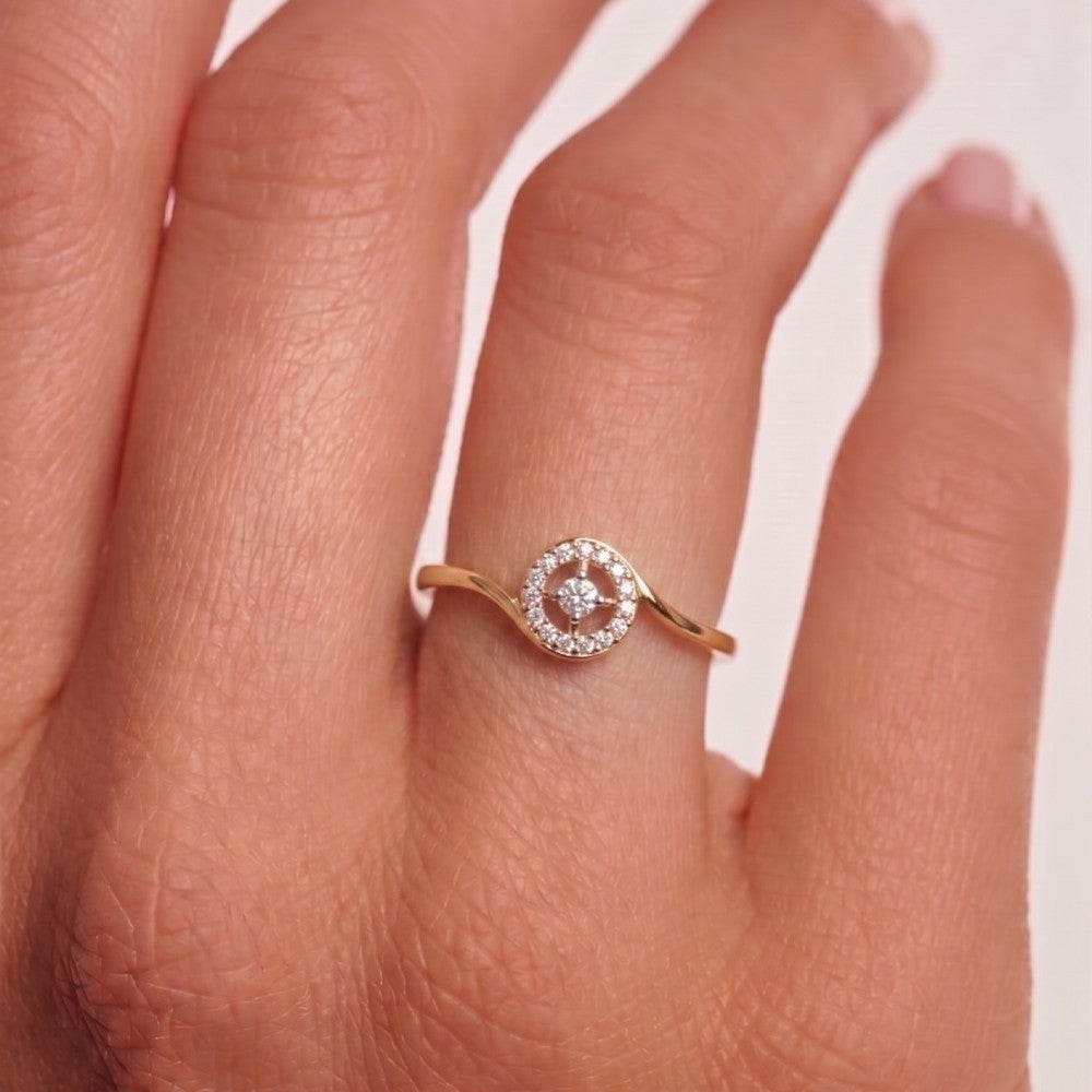Rose gold ring with diamonds on a finger against a light background