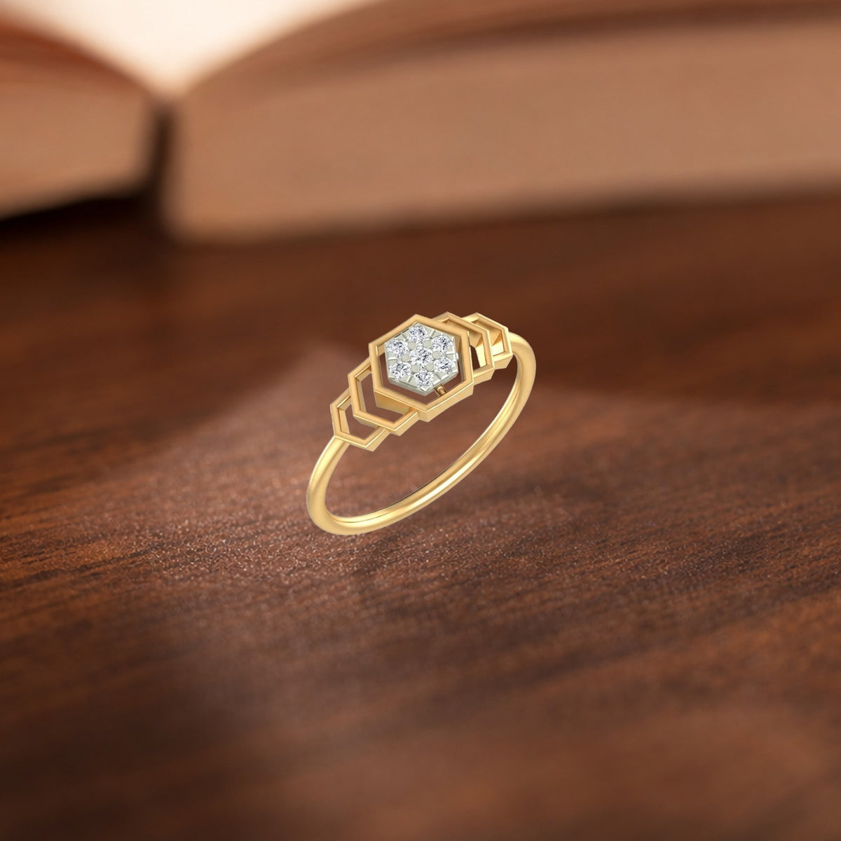 A gold ring with a geometric hexagonal setting, displayed on a textured wooden surface.