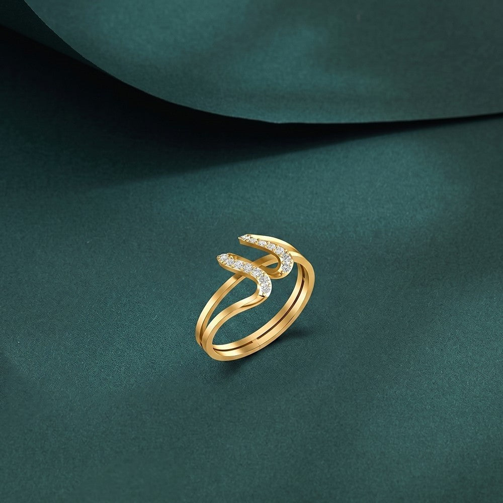 Gold ring with diamond accents on a dark green fabric background