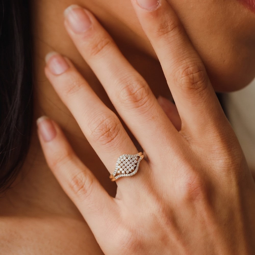 Close-up of a hand wearing a diamond ring with a soft focus background