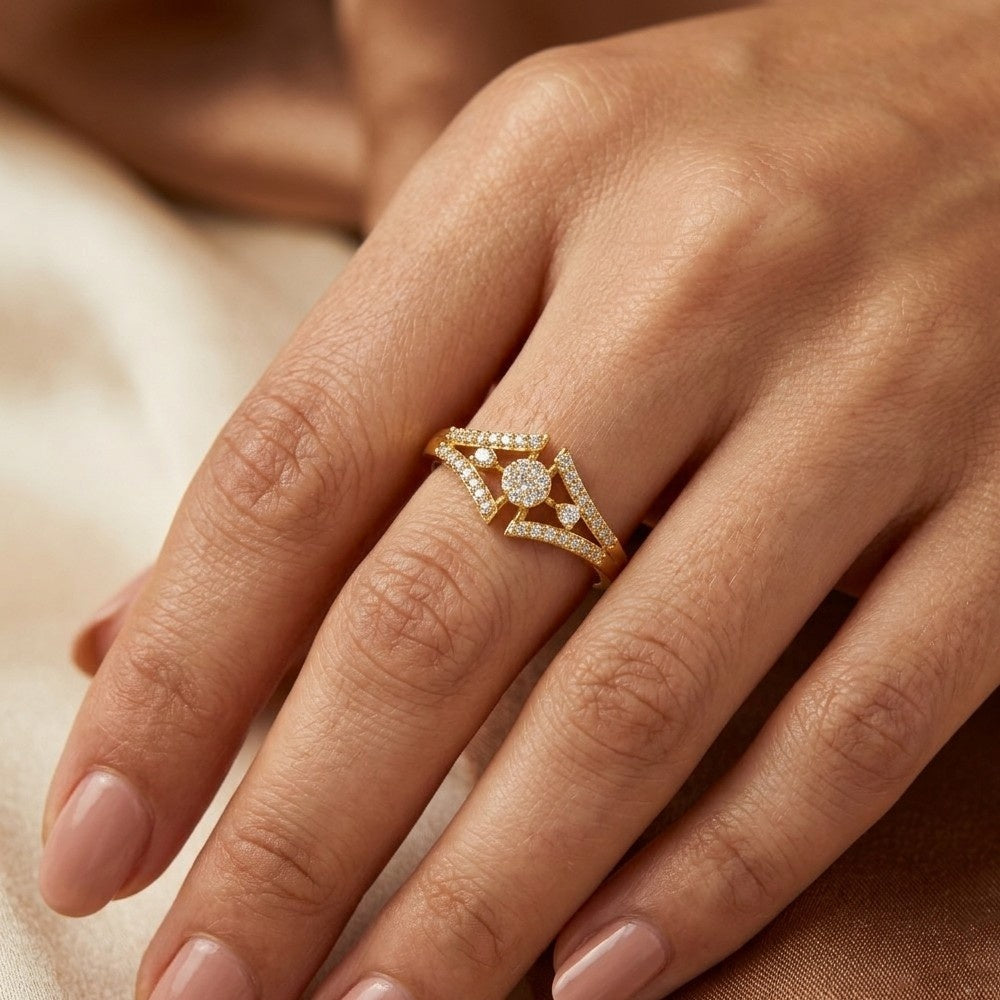 A close-up view of a person's hand wearing a yellow gold ring with an intricate
