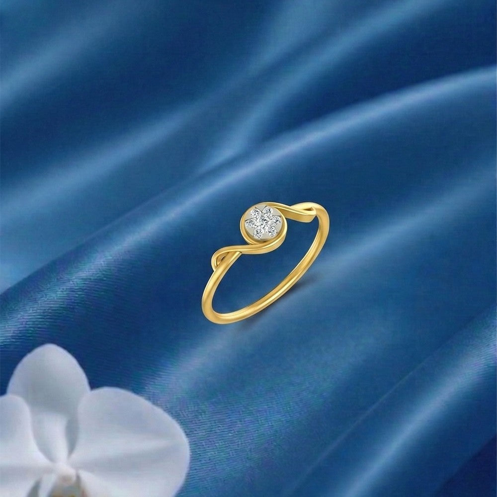 Gold and diamond with circular cluster setting on a blue fabric surface.