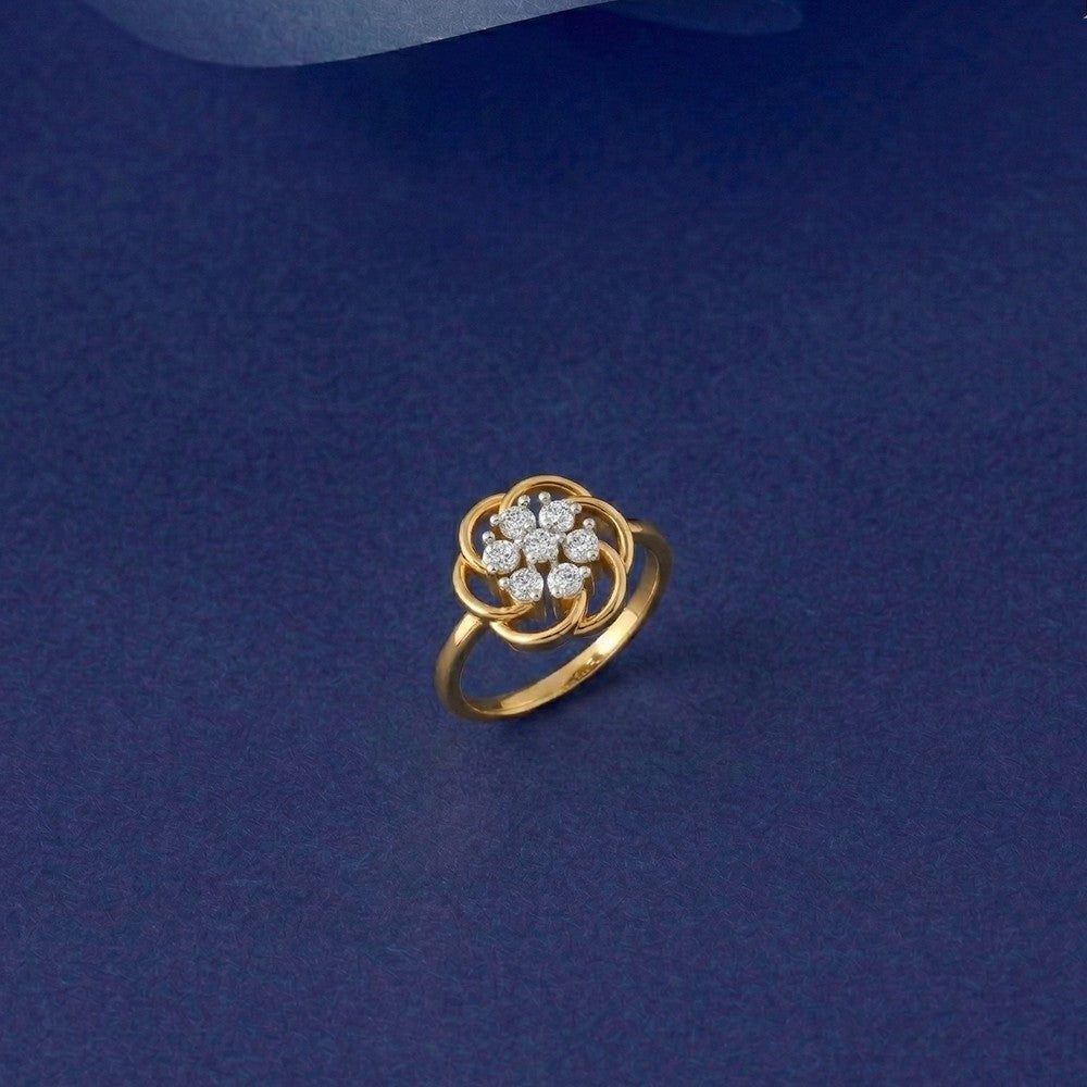 Gold and diamond with floral-design cluster setting on a blue surface.