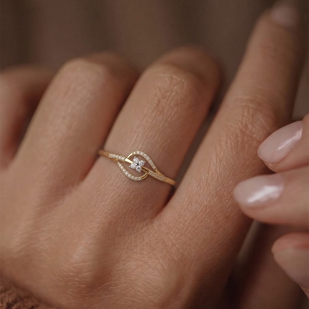 Gold ring with a diamond on a person's finger against a neutral background