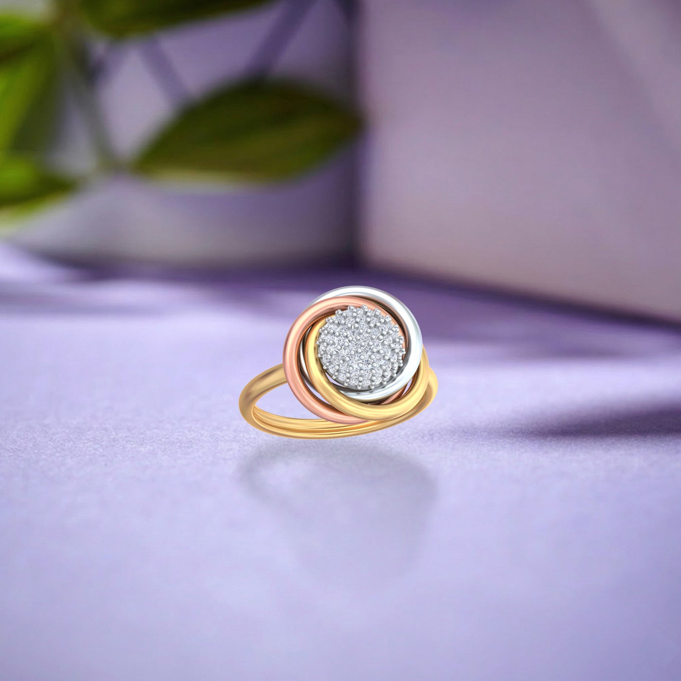 A gold ring with a textured silver center, featuring gold, rose gold, and white gold bands, resting on a light purple surface.