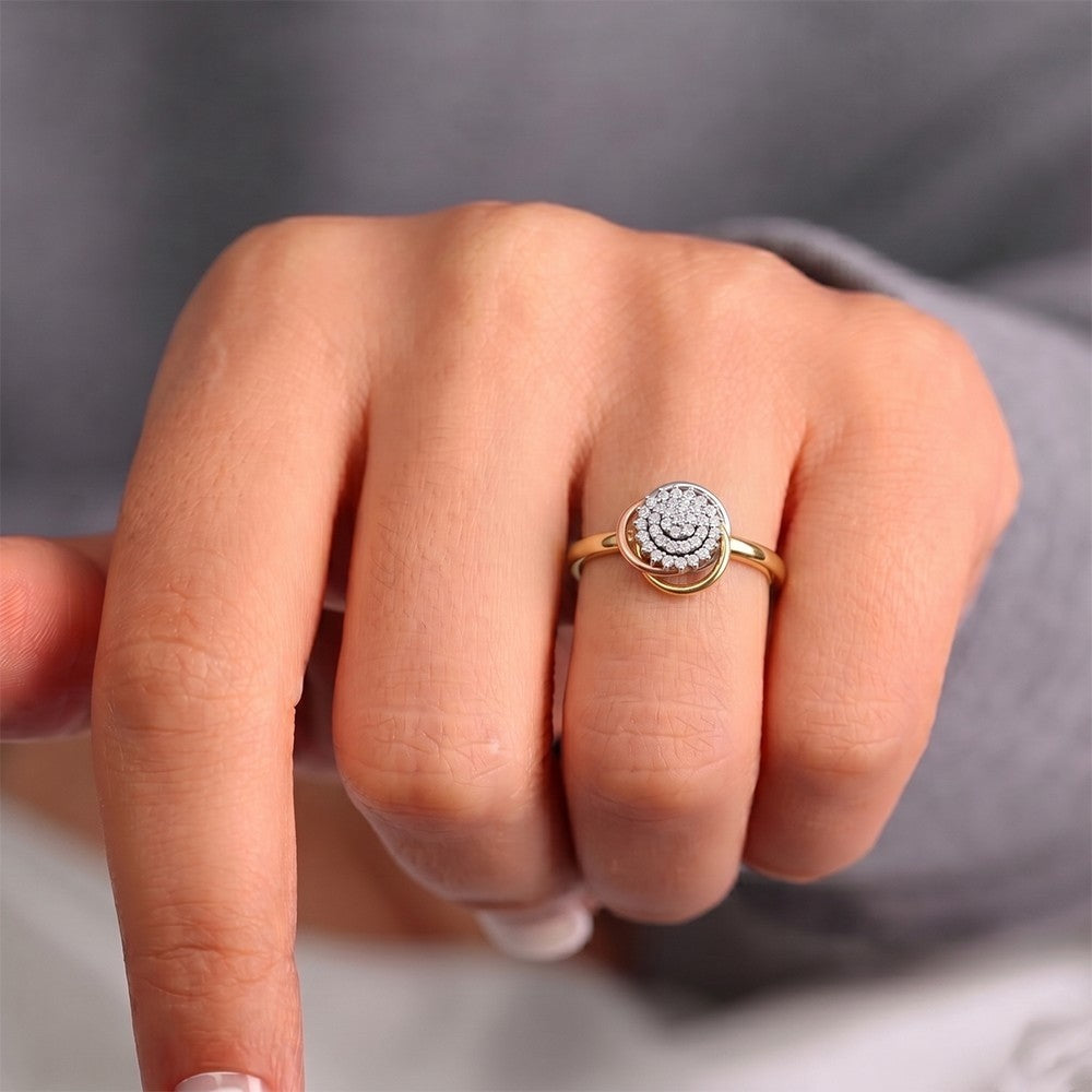 Close-up of a hand wearing a gold ring with a diamond design on a neutral background