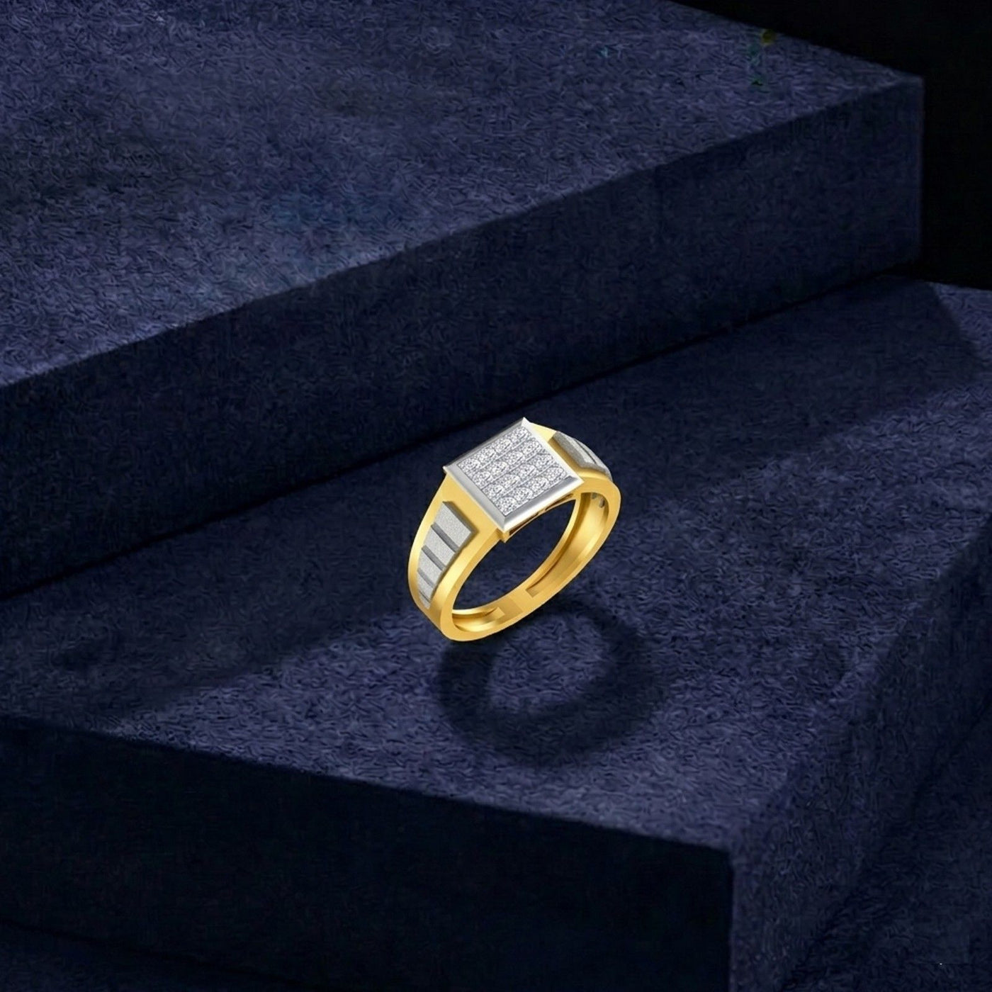 A men's gold signet ring with a textured, displayed on a dark navy blue velvet block.