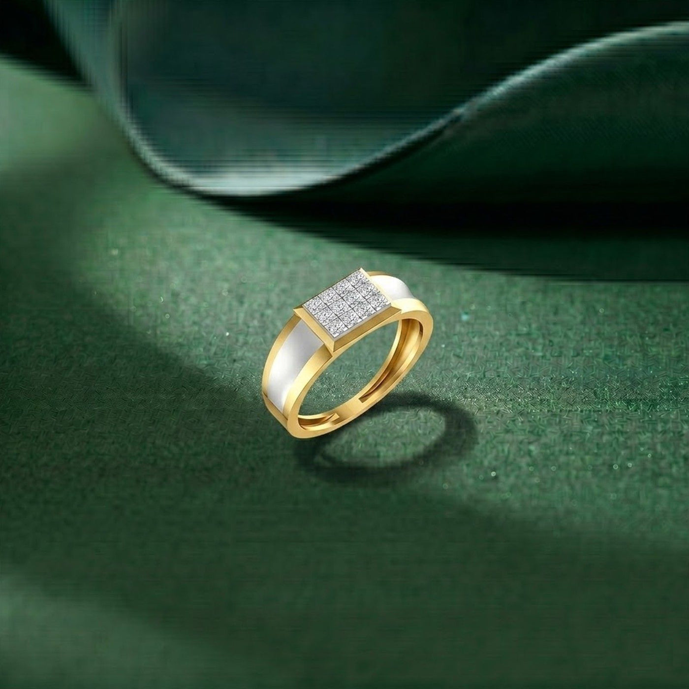 Gold ring with a silver square stone on a green surface