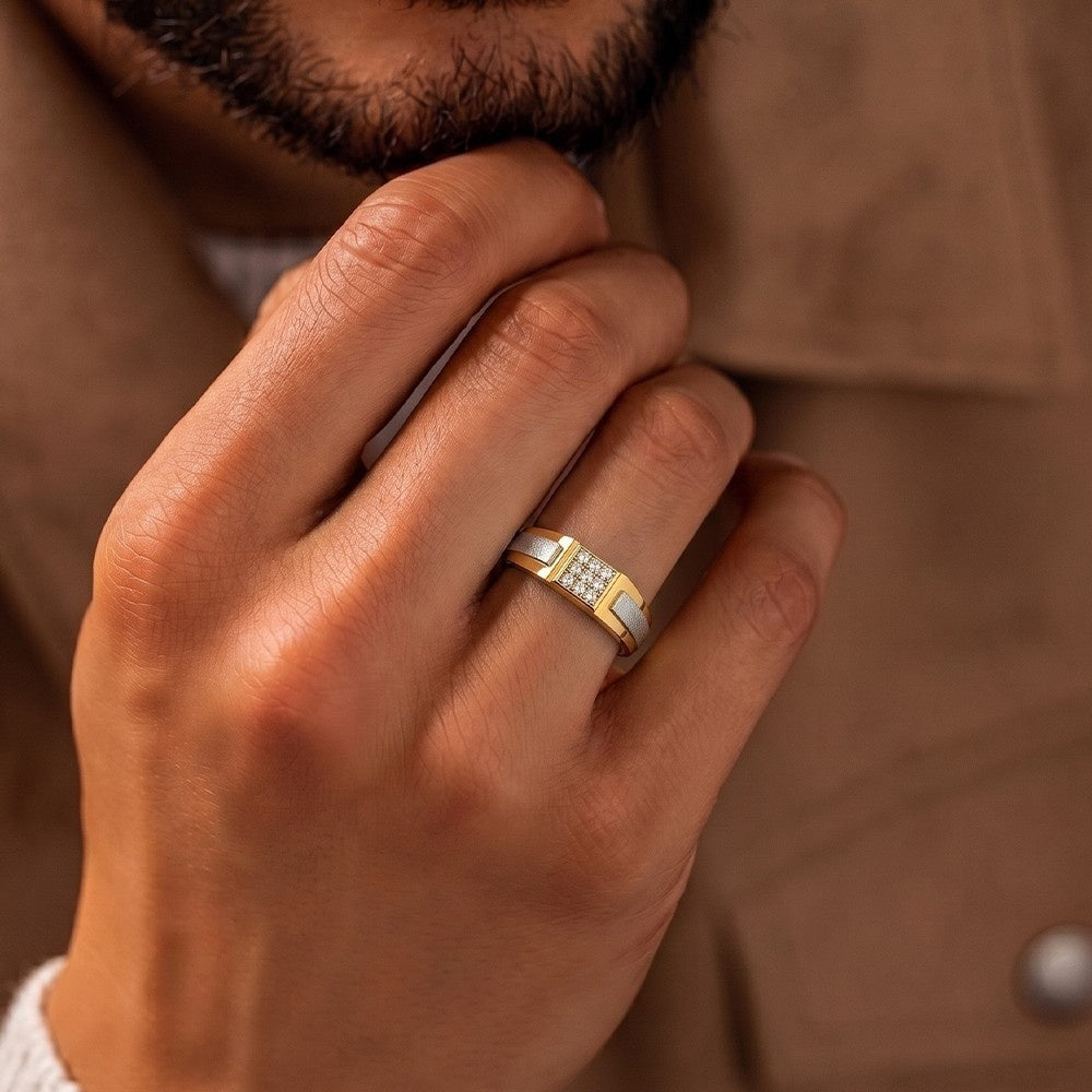 Men's wearing a gold and diamond ring  with a square diamond cluster on top.