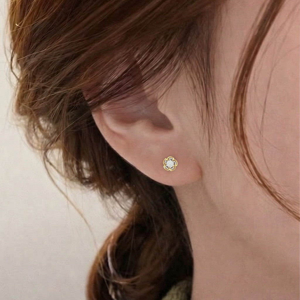 A close-up of a person's ear wearing a gold and diamond stud earring.
