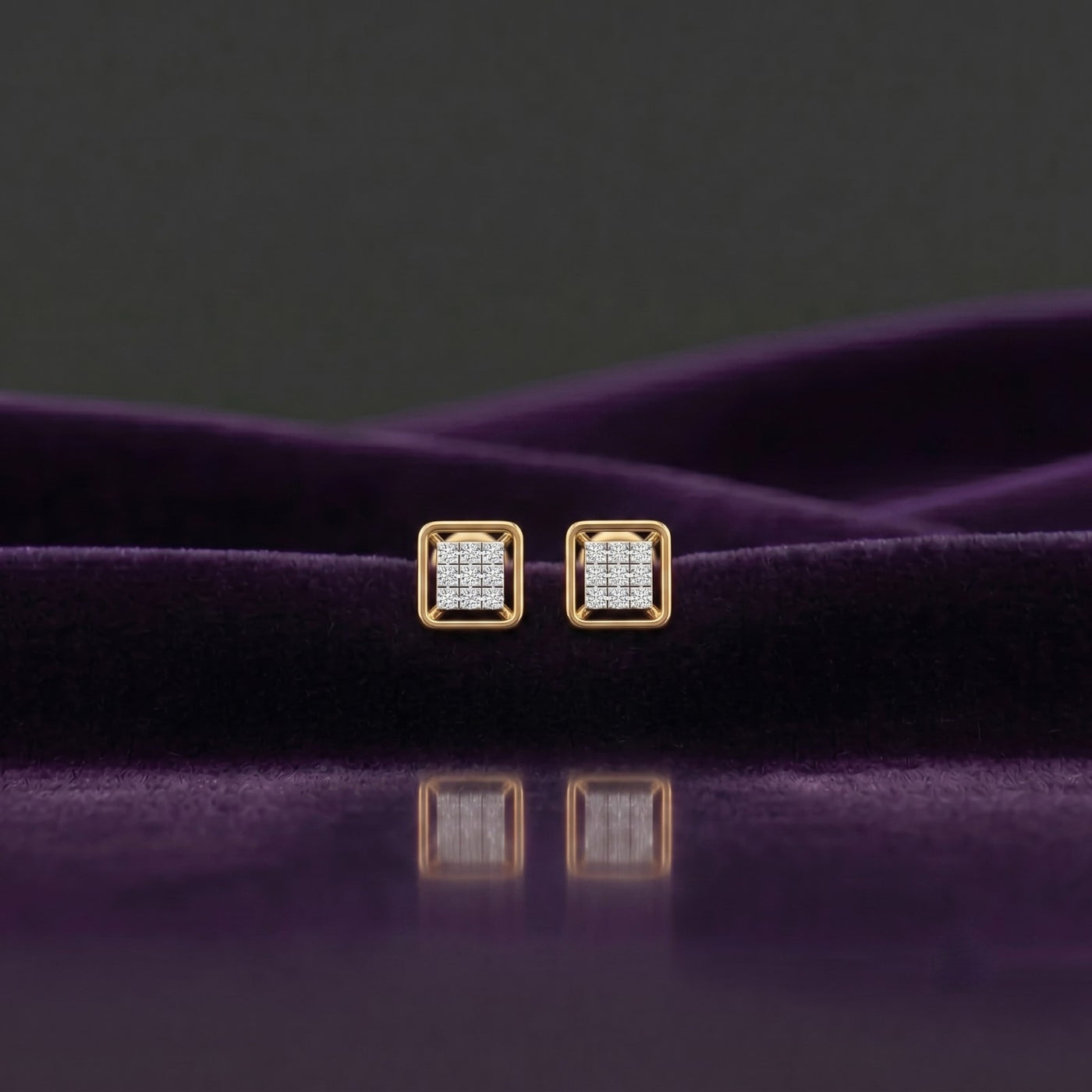 Gold square-shaped stud earrings on a purple surface.