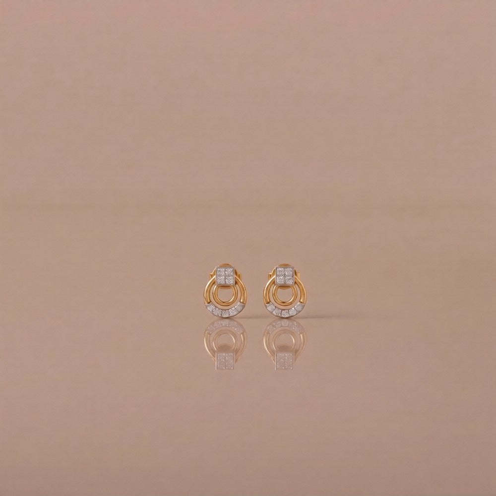 Gold and diamond stud earrings on a beige background.