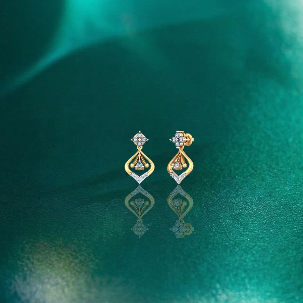 Gold and diamond earrings on a green textured background.