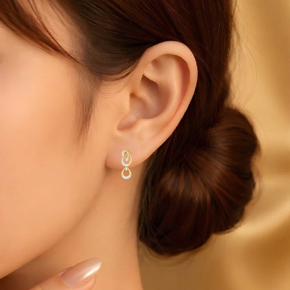 Close-up of an ear wearing a gold and diamond earring with a blurred background.