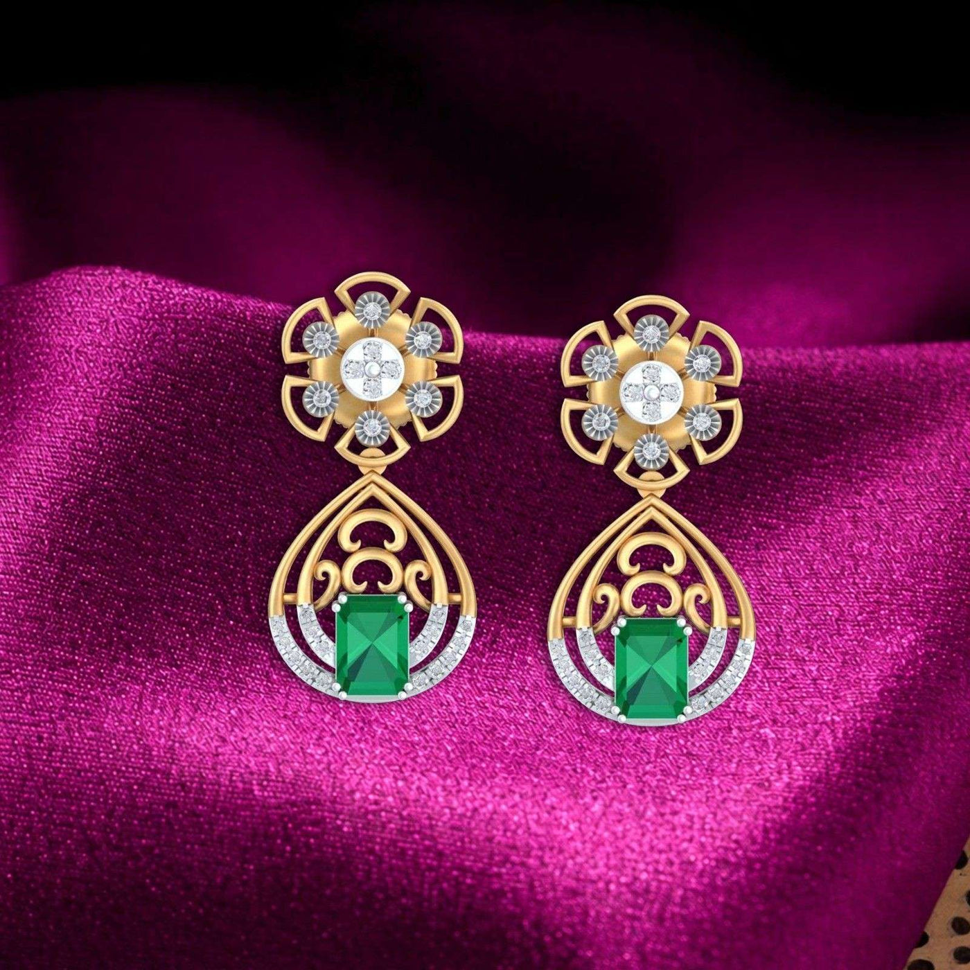 Gold and diamond earrings with green gemstones on a magenta fabric background.