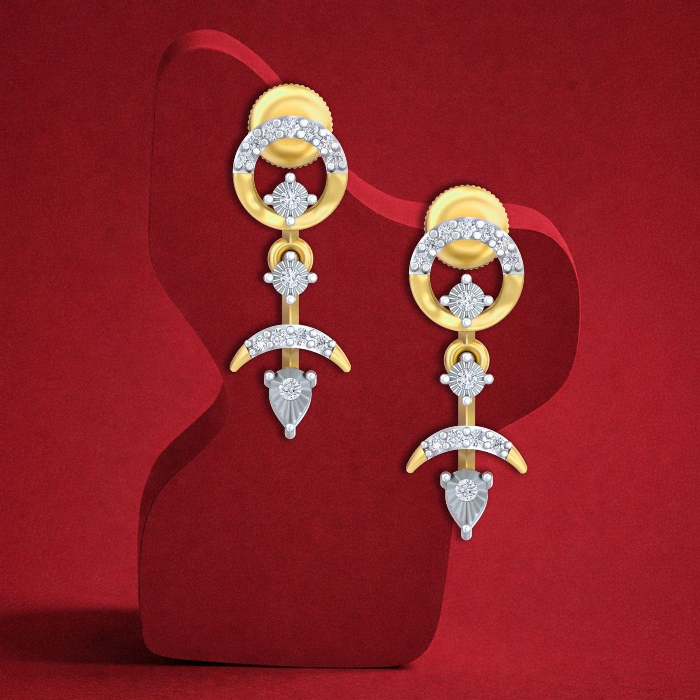 A pair of gold and diamond drop earrings displayed on a red sculptural stand against a red background.