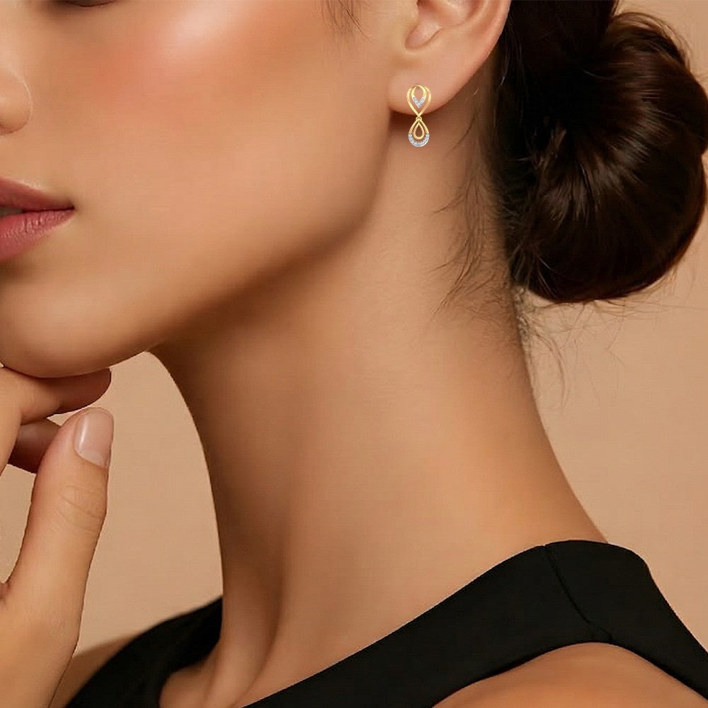 Close-up of a woman wearing gold drop earrings.