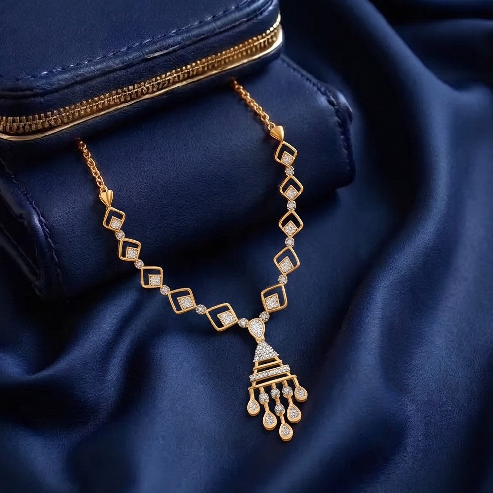 Gold necklace with diamond accents on a blue fabric background