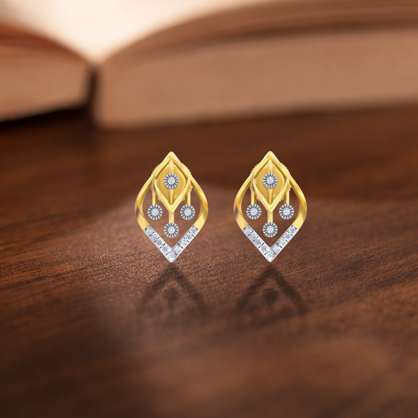 Gold and diamond stud earrings on a wooden surface