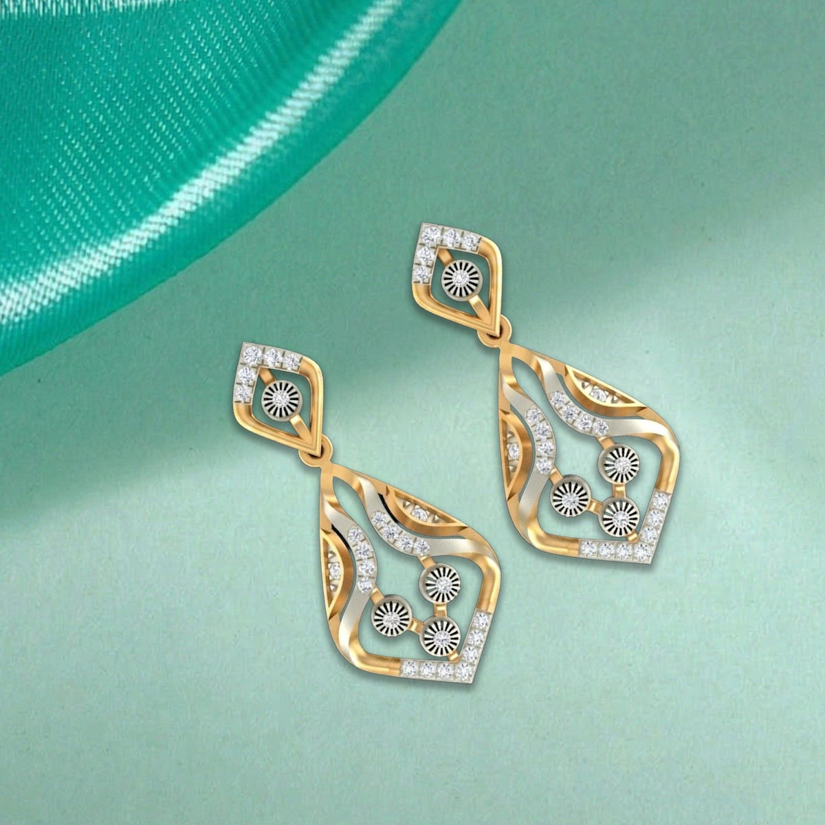 A pair of gold and diamond drop earrings with diamond, displayed on a light mint green background.