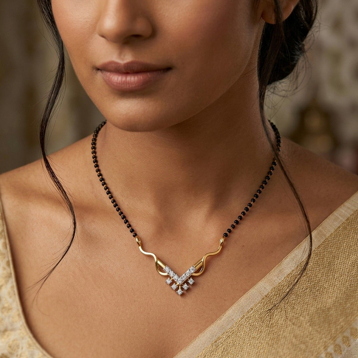 A close-up of a person wearing a black beaded mangalsutra with a geometric, V-shaped gold and diamond mangalsutra