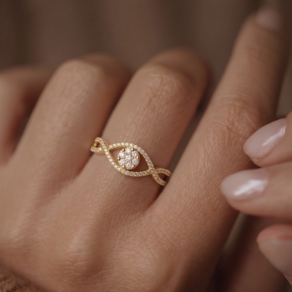 Gold ring with a diamond on a person's finger against a neutral background.