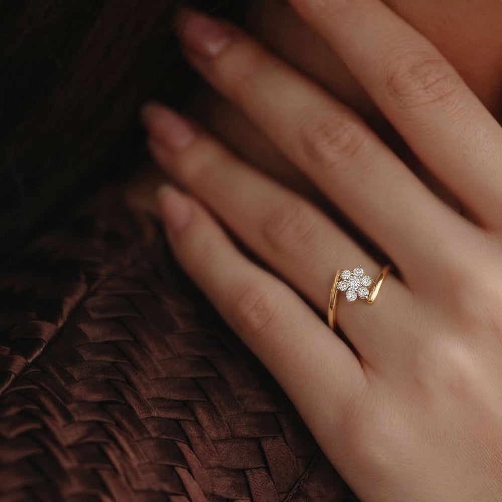 A close-up of a hand wearing a delicate gold and diamond ring.